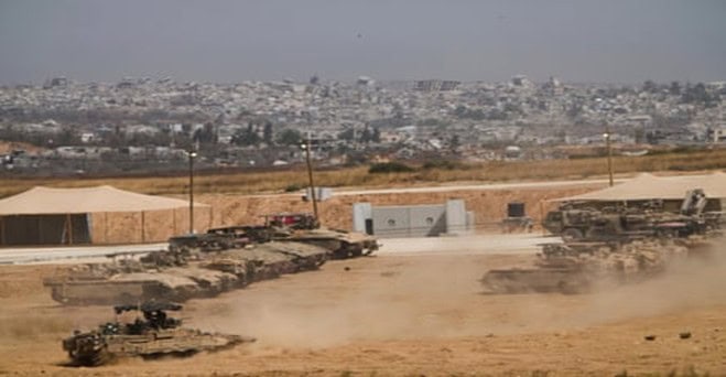 Israeli tanks and armored vehicles around the Gaza border in May. The steel and aluminum used to make weapons are very carbon-intensive to produce. Photo: Ariel Shalit/AP